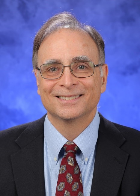A person wearing glasses and a suit AI-generated content may be incorrect.